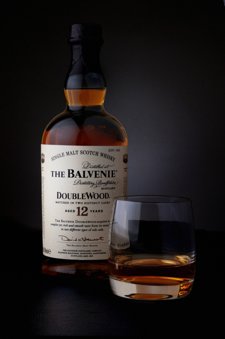 Photographie packshot d'une bouteille et d'un verre de whisky.
