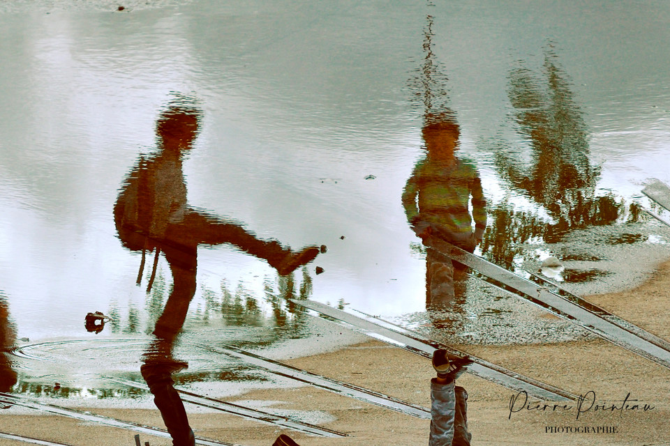 Le reflet d'enfants jouant dans une flaque.